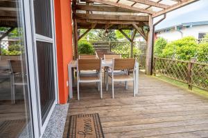 a wooden deck with a table and chairs at Mö 71-Inselblick in Mönkebude