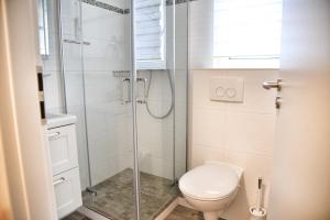 a bathroom with a toilet and a glass shower at Lagunenstadt am Haff - Fewo 166 Nautilus in Ueckermünde