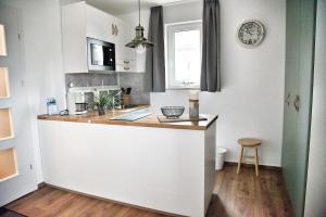 a kitchen with a counter and a kitchen island with a clock at Lagunenstadt am Haff - Fewo 166 Nautilus in Ueckermünde