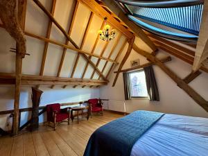 a bedroom with a bed and a table and chairs at Erfgoed & Logies Den Heijkant in Moergestel