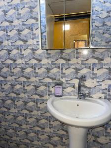 a bathroom with a sink and a mirror at Résidence KUYITO in Kaolack