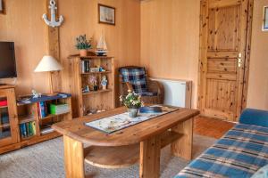a living room with a wooden table and a couch at Strandhaus 38 in Mönkebude