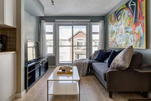 a living room with a couch and a large window at Stylish Mountain View Condo with Gym in Canmore