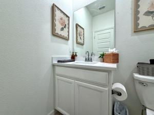a white bathroom with a sink and a mirror at Attached Guest House in Woodland +17 photos