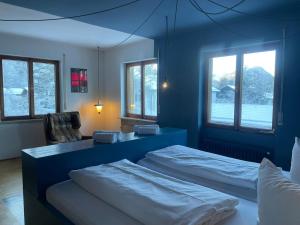 a blue room with two beds and a chair at King Ludwig's Old Neighbour in Schwangau