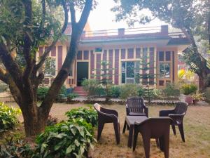 a group of chairs and a table in front of a building at Corbett Bungalow Stay- Private Garden Stay Near Jim Corbett in Rāmnagar