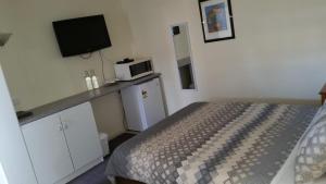 a small bedroom with a bed and a microwave at Kaniva Midway Motel in Kaniva