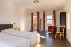 a hotel room with two beds and a chair at Summio Havenresort Terherne in Terherne