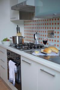 a kitchen with a stove with bread and a glass of wine at Casale DI Tormaggiore Villa And Country Suites in Pomezia