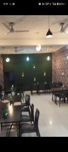 a dining room with tables and chairs and a green wall at Shanti palace and restaurant Ayodhya 1500 mtr Sri Ram Mandir ,near ayodhya dham railway station in Ayodhya