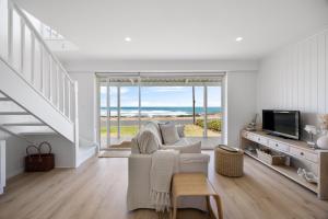 a living room with a white couch and a television at Nest at Bashams - A Panoramic Oceanfront Sanctuary in Middleton
