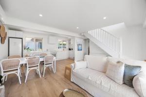 a living room with a white couch and a table at Nest at Bashams - A Panoramic Oceanfront Sanctuary in Middleton