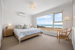 a bedroom with a bed and a view of the ocean at Nest at Bashams - A Panoramic Oceanfront Sanctuary in Middleton