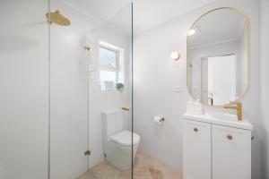 a white bathroom with a toilet and a mirror at Nest at Bashams - A Panoramic Oceanfront Sanctuary in Middleton +20 photos