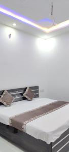 a bed in a room with a light on the wall at Shanti palace and restaurant Ayodhya 1500 mtr Sri Ram Mandir ,near ayodhya dham railway station in Ayodhya