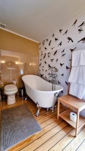 a bathroom with a white tub and bats on the wall at Lantlivlodge i Österjörn -Herrgård in Österjörn +58 photos