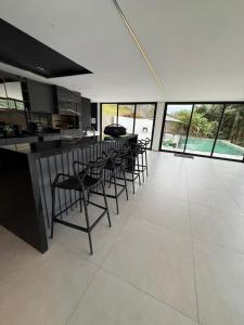 a room with chairs and a bar in a kitchen at Resilience Igaratá in Igaratá