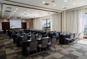 a conference room with tables and chairs and a screen at Catalonia Santo Domingo in Santo Domingo +144 photos