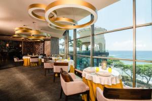 a restaurant with tables and chairs and large windows at Catalonia Santo Domingo in Santo Domingo