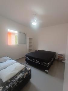 a bedroom with two beds in a room at Boracéia Apto 1 quarto in Bertioga