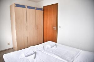 a bedroom with a bed and a wooden closet at Lagunenstadt am Haff - Fewo 4 Muschel in Ueckermünde