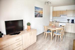 a kitchen and dining room with a table and a television at Lagunenstadt am Haff - Fewo 4 Muschel in Ueckermünde
