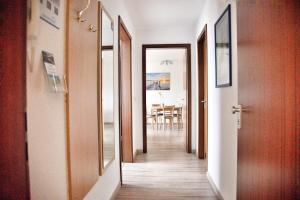 a hallway with doors and a dining room with a table at Lagunenstadt am Haff - Fewo 4 Muschel in Ueckermünde +14 photos