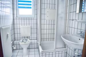 a white bathroom with a toilet and a sink at Lagunenstadt am Haff - 47 Kehr wieder! in Ueckermünde