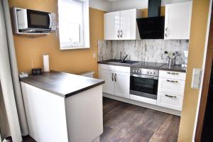 a kitchen with white cabinets and a stove top oven at Lagunenstadt am Haff - 47 Kehr wieder! in Ueckermünde