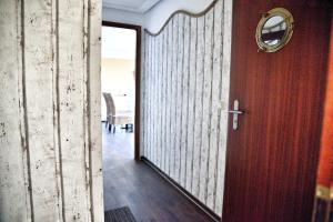 a hallway with a wooden door and a table at Lagunenstadt am Haff - 47 Kehr wieder! in Ueckermünde