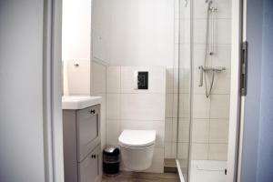 a white bathroom with a toilet and a shower at Lagunenstadt am Haff - Fewo 181 Kogge in Ueckermünde