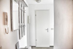 a hallway with a white door and a mirror at Lagunenstadt am Haff - Fewo 181 Kogge in Ueckermünde