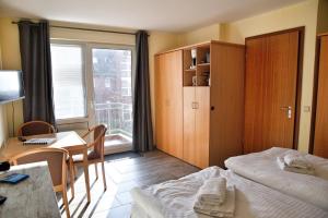 a hotel room with a bed and a desk and a window at Lagunenstadt am Haff - Fewo 196 Gaffel in Ueckermünde