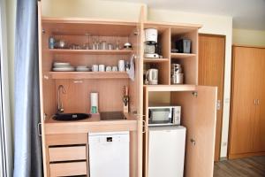 a small kitchen with a sink and a microwave at Lagunenstadt am Haff - Fewo 196 Gaffel in Ueckermünde