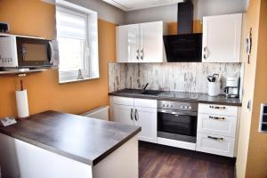 a kitchen with white cabinets and a counter top at Lagunenstadt am Haff - Fewo 72 Flip in Ueckermünde