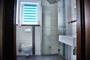 a bathroom with a toilet and a sink and a window at Lagunenstadt am Haff - Fewo 72 Flip in Ueckermünde