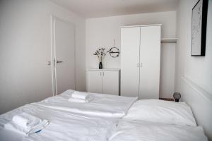 a white bedroom with a bed with white sheets at Lagunenstadt am Haff - 80 Kai in Ueckermünde