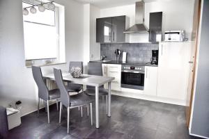 a kitchen with a dining room table and chairs at Lagunenstadt am Haff - Fewo 34 Palstek in Ueckermünde