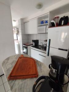 a kitchen with a wooden cutting board on a counter at Cumbuco Geek House in Cumbuco