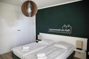 a bedroom with a bed with a green wall at Lagunenstadt am Haff - 119 Marina in Ueckermünde