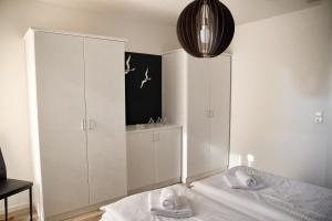 a white bedroom with a bed and a cabinet at Lagunenstadt am Haff - 119 Marina in Ueckermünde