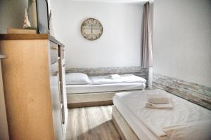 two beds in a room with a clock on the wall at Lagunenstadt am Haff - 119 Marina in Ueckermünde