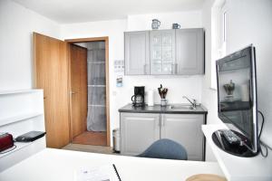 a kitchen with white cabinets and a desk with a chair at Lagunenstadt am Haff - 189 Stromer in Ueckermünde