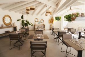 a restaurant with tables and chairs and a fireplace at Gabbiano Azzurro Hotel & Suites in Golfo Aranci