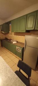 a kitchen with green cabinets and a chair at Hotel Necochea in Mendoza