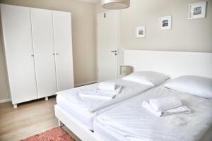 a bedroom with a white bed with white cabinets at Lagunenstadt am Haff - Fewo 161 Arielle in Ueckermünde