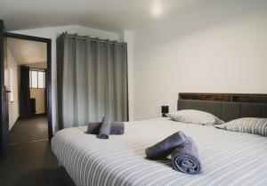 a bedroom with a large bed with blue towels on it at Le Passage - Centre-ville - WiFi in Issoire