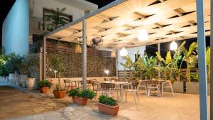 a restaurant with tables and chairs and potted plants at Amaryllis in Platanias