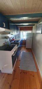 a kitchen with a white stove and a wooden floor at Sunset Cabin in Ålesund