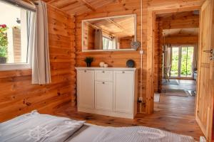 a bedroom in a log cabin with a mirror at Ferienhaus Ankerplatz Bellin in Ueckermünde +20 photos